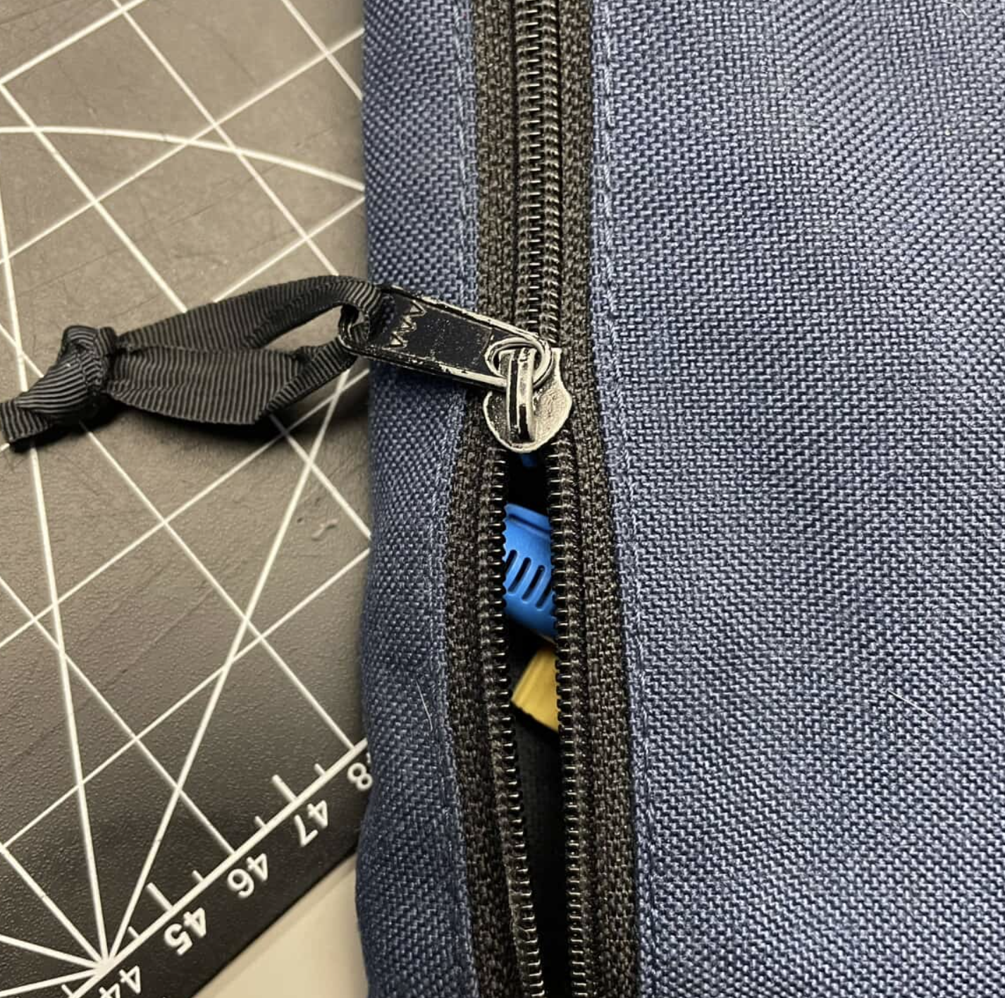This zipper is on a pencil case made of canvas with little to no decoration. With the circuit being complete a light can appear to indicate to viewsers it is adequatly closed.